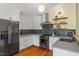 Kitchen with stainless appliances, gray tile backsplash, and floating wood shelves at 3213 Mid Pines Rd, Raleigh, NC 27606