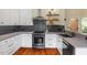 Kitchen featuring stainless appliances, gray tile backsplash, and white cabinets at 3213 Mid Pines Rd, Raleigh, NC 27606