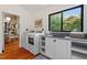 Laundry room with stainless sink, lots of natural light, and wood floors at 3213 Mid Pines Rd, Raleigh, NC 27606