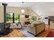 Bright living room with hardwood floors, wood burning stove, and large windows at 3213 Mid Pines Rd, Raleigh, NC 27606