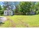 Exterior shot showing two outbuildings on the property with a partial view of wooden fence at 3213 Mid Pines Rd, Raleigh, NC 27606