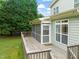 A wood back deck next to a screened in porch and a door to the home at 322 Bellemont Rd, Pittsboro, NC 27312