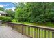 A wood back deck overlooking a lush green backyard with trees in the distance at 322 Bellemont Rd, Pittsboro, NC 27312