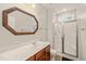 Bathroom with wood vanity, large mirror, and walk-in shower with glass door at 322 Bellemont Rd, Pittsboro, NC 27312