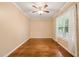 Cozy bedroom with hardwood flooring, ceiling fan, and a window providing natural light at 322 Bellemont Rd, Pittsboro, NC 27312