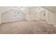 A spacious bonus room featuring neutral carpet, ample natural light, and two ceiling fans at 322 Bellemont Rd, Pittsboro, NC 27312