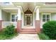 Welcoming front porch with stately columns, brick base, and a stylish entrance at 322 Bellemont Rd, Pittsboro, NC 27312