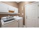 Well-lit laundry room features washer, dryer, cabinets and door at 322 Bellemont Rd, Pittsboro, NC 27312
