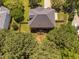 Aerial view of the home showing the roof, fenced backyard, deck, mature trees, and surrounding landscape at 406 Dairy Farm Dr, Hillsborough, NC 27278