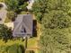 Home aerial view showcasing a well-maintained backyard, roof, and lush surrounding trees for added privacy at 406 Dairy Farm Dr, Hillsborough, NC 27278