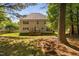 Spacious, well-kept backyard with mature trees shading the lawn and a deck attached to the two-story home at 406 Dairy Farm Dr, Hillsborough, NC 27278