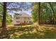 Large backyard featuring a deck, well-kept lawn, mature trees, and the back of the two-story residence at 406 Dairy Farm Dr, Hillsborough, NC 27278