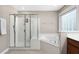 Bathroom features a glass enclosed shower, soaking tub, and window that offers natural light at 406 Dairy Farm Dr, Hillsborough, NC 27278