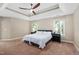 Spacious bedroom boasts a tray ceiling with fan, plush carpeting, and two windows allowing lots of light at 406 Dairy Farm Dr, Hillsborough, NC 27278