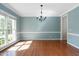 Open dining room boasts hardwood floors, decorative lighting, wainscoting, and a large window for lots of light at 406 Dairy Farm Dr, Hillsborough, NC 27278