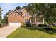 Charming brick two-story home with well-manicured lawn and inviting front porch at 406 Dairy Farm Dr, Hillsborough, NC 27278