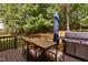 View of outdoor deck with grill, patio table, umbrella, and wooded yard at 406 Dairy Farm Dr, Hillsborough, NC 27278