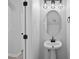 Chic bathroom features a pedestal sink with caged lighting and modern black fixtures at 4536 Sugarbend Way, Raleigh, NC 27606