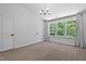 Bright bedroom with three windows, neutral carpet and walls, plus a modern chandelier at 4536 Sugarbend Way, Raleigh, NC 27606