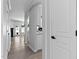 Arched doorway leads into a bright, neutral kitchen from a hallway with light flooring at 4536 Sugarbend Way, Raleigh, NC 27606