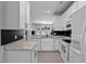 Bright, modern kitchen featuring white cabinetry, stone countertops, and stainless steel appliances at 4536 Sugarbend Way, Raleigh, NC 27606