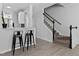 Bright living room features a breakfast bar, two stools, and a staircase with wood railing and carpeted stairs at 4536 Sugarbend Way, Raleigh, NC 27606