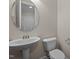 Stylish half bathroom with pedestal sink, round mirror, and updated fixtures at 469 Methven Grove Dr, Cary, NC 27519