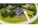 A beautifully landscaped home with dormer windows and a circular driveway surrounded by lush greenery at 4725 Saratoga Falls Ln, Raleigh, NC 27614