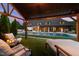 Evening view of the backyard featuring a beautiful inground pool and relaxing pergola seating at 4725 Saratoga Falls Ln, Raleigh, NC 27614