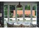 A backyard view with a swimming pool, and lush, manicured landscaping seen through large windows at 4725 Saratoga Falls Ln, Raleigh, NC 27614
