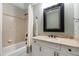 Bathroom features a tiled shower-tub combo and vanity with a framed mirror at 4725 Saratoga Falls Ln, Raleigh, NC 27614