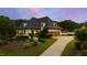 This beautiful home is set against a colorful dusky sky and a three car garage at 4725 Saratoga Falls Ln, Raleigh, NC 27614