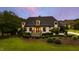 Stunning home with manicured lawn, dark roof, and exterior lighting at twilight at 4725 Saratoga Falls Ln, Raleigh, NC 27614