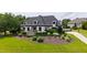 Stately home with meticulously landscaped front yard, features a circular driveway and stone accents for a welcoming entrance at 4725 Saratoga Falls Ln, Raleigh, NC 27614