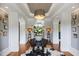 Inviting foyer with decorative table, mirrors, lamps, hardwood floors, and arched doorways at 4725 Saratoga Falls Ln, Raleigh, NC 27614