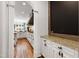 Hallway leading to a bright eat-in kitchen featuring white cabinets, granite countertops, and a wood range hood at 4725 Saratoga Falls Ln, Raleigh, NC 27614