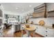A bright eat-in kitchen with white cabinets, granite countertops, stainless steel appliances, and a wood range hood at 4725 Saratoga Falls Ln, Raleigh, NC 27614