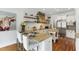 Eat-in kitchen with white cabinetry, a wood range hood, floating shelves, granite counters, and stainless steel appliances at 4725 Saratoga Falls Ln, Raleigh, NC 27614