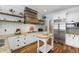 Bright eat-in kitchen featuring white cabinets, granite countertops, stainless steel appliances, and a wood range hood at 4725 Saratoga Falls Ln, Raleigh, NC 27614