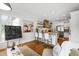 Open-concept kitchen with white cabinetry, a wood range hood, floating shelves, granite counters, stainless appliances, and eat-in island at 4725 Saratoga Falls Ln, Raleigh, NC 27614