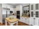 A bright kitchen with white cabinets, stainless steel appliances, granite countertops, and wooden island table at 4725 Saratoga Falls Ln, Raleigh, NC 27614