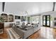 Open living room with fireplace, built-ins, a gray sectional couch, and access to the pool at 4725 Saratoga Falls Ln, Raleigh, NC 27614