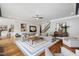 Open living room with a large sectional sofa, hardwood floors, and staircase to the second floor at 4725 Saratoga Falls Ln, Raleigh, NC 27614