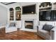 Living room features a fireplace, built-ins, hardwood floors, and two comfortable chairs at 4725 Saratoga Falls Ln, Raleigh, NC 27614