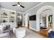 Comfortable living room with built-in shelving, arched doorways, and a neutral color palette at 4725 Saratoga Falls Ln, Raleigh, NC 27614