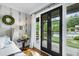Main bedroom with French doors overlooking landscaped backyard and swimming pool, seamlessly blending indoor and outdoor living at 4725 Saratoga Falls Ln, Raleigh, NC 27614