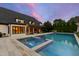 A luxurious pool and spa with an outdoor living space and pergola at dusk make for idyllic backyard at 4725 Saratoga Falls Ln, Raleigh, NC 27614