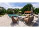 A refreshing inground pool with tanning ledge is surrounded by stone pavers and manicured landscaping at 4725 Saratoga Falls Ln, Raleigh, NC 27614