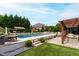 An inground pool is surrounded by stone patio, a covered pergola, and lush landscaping at 4725 Saratoga Falls Ln, Raleigh, NC 27614