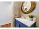 Powder room features a marble countertop vanity, gold hardware, and a unique circular mirror at 4725 Saratoga Falls Ln, Raleigh, NC 27614